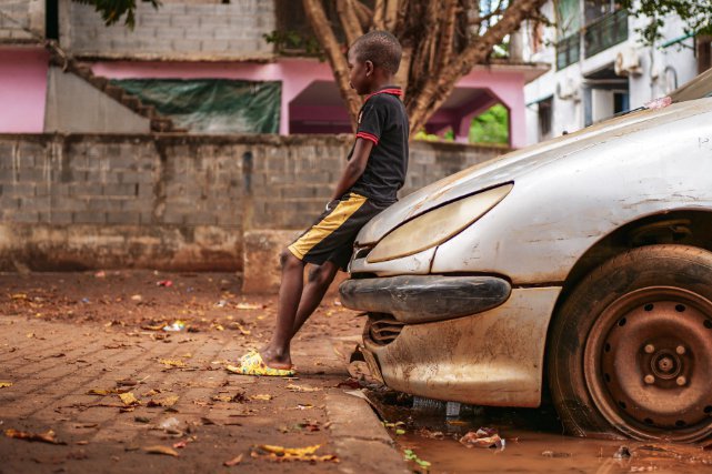 Un enfant est assis sur le capot d une carcasse de voiture, laissee a l abandon en pleine rue a Doujani, village appartenant a la commune de Mamoudzou, chef lieu de Mayotte. Les vehicules hors d usage sont tres presents a Mayotte. 