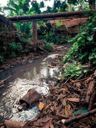 La rivière Ourogoni serpente entre les habitations et est détériorée par les déchets ménagers. 
