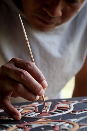 Minestelli Ananuman, artisan d'Antecume-Pata, 
réalisant les motifs d'un maluwana. 
