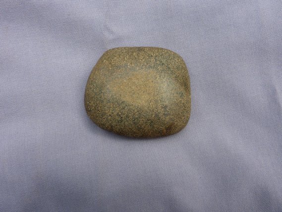 Lame de hache en pierre verte et perle en coquillage provenant de la sépulture Tukuwari 4.
